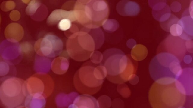 Vibrant Bokeh: A captivating display of soft, out-of-focus circles dance across a rich burgundy backdrop, creating an abstract tapestry of color and light.