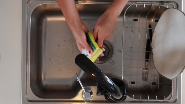 Mulher lavando lou&ccedil;a na cozinha 