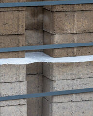 Construction site with stacked concrete blocks and water on a surface during the day