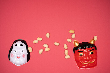 Traditional Setsubun masks and roasted beans on festive backdrop
