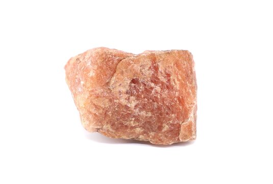 Piece of raw Sunstone, orange feldspar mineral, used as semi precious gemstone. White background.