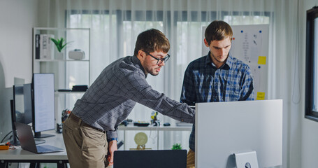 Team adult male engineer collaborate on robotic hand project using AI code solutions machine learning at tech workspace. Artificial intelligence interface, collaboration support prototype development.