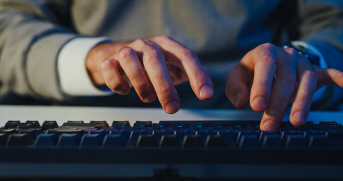 Closeup young adult male freelance developer typing write prompt AI bot app program nomad terminal coding at office night. Artificial intelligence dashboard, robotics user interface, machine learning.