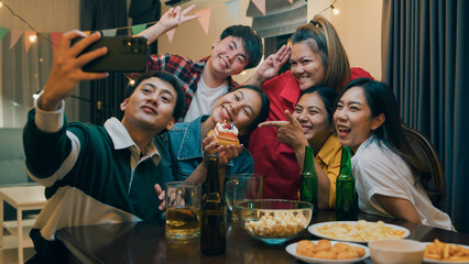 Group of young adult Asia friend with birthday cake look at camera shooting video photo on mobile app fun hangout party in night life indoor home. Happy hour time millennial generation inside house.