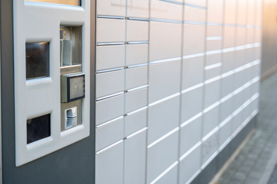 Parcel locker station with service terminal in foreground and rows of lockers behind