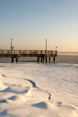 Fototapeta premium Wooden pier and frozen Baltic sea in Kuznica. Winter landscape on Hel Peninsula. Poland, Europe