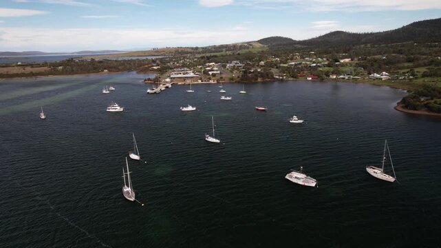 Sailboats Floating In The Calm Water Of Blackman Bay - Dunalley, Tasmania, Australia. - aerial shot