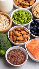 Assorted bowls of nuts, seeds, greens, and a salmon slice arranged on a white surface with color and texture!!