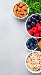 Five bowls of nuts, greens, and berries arranged vertically on a light gray surface, fresh and colorful vivid