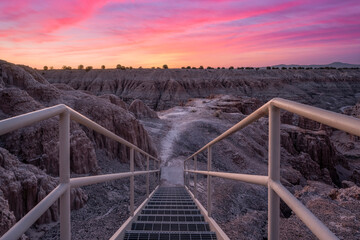 Stairs leading towards a trail into a Nevada gorge at sunrise