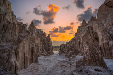 Pathway through jagged rock formation leading towards a sunset in the remote Nevada desert terrain 