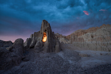 Dark storm clouds over an illuminated rock cave in Cathedral Gorge State Park Nevada 