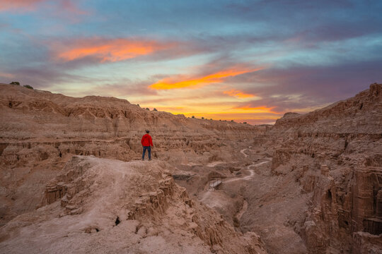 Man hiking in a red jacket overlooking Cathedral Gorge at Millers Point in Nevada 