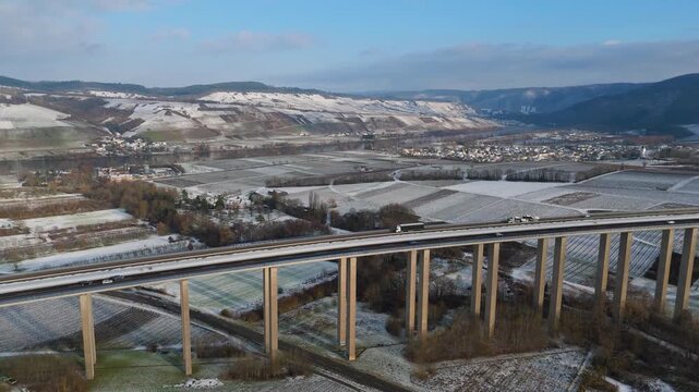 Moselle vineyard, Viaduct Longuich, Mosel valley, snow in winter season, bridge of highway crossing river near Trier, aerial view