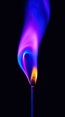 A vibrant, multicolored flame ignites from a matchstick, casting an ethereal glow against a deep black background. The striking fire displays a beautiful gradient of intense blue, captivating purple, 