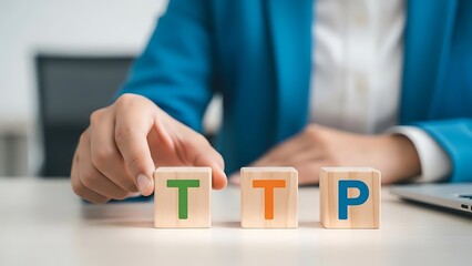 Businessperson arranging wooden blocks with letters ttp on office desk