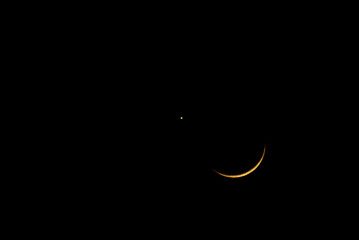 Crescent moon beside the moon through telescope