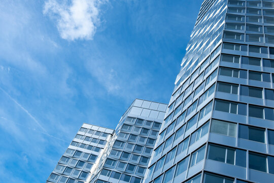 Modern paris city architecture skyscraper building with facade rising upward into sky with clouds for corporate business finance district background