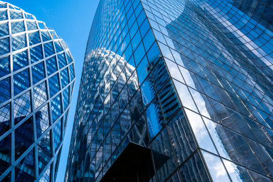 Modern paris city architecture skyscraper glass tower with geometric facade curve rising upward in clear sky for corporate business finance concept
