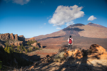 Hiker with Backpack Contemplating Dramatic Volcanic Landscape of Mount Teide in Tenerife, Canary...