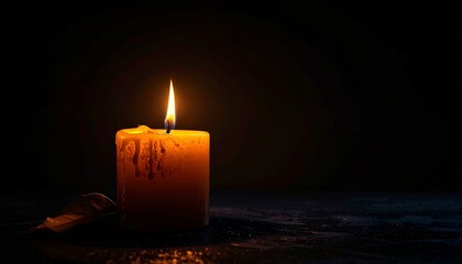 Soft light from a burning candle in a dark room creating shadows on a flat surface