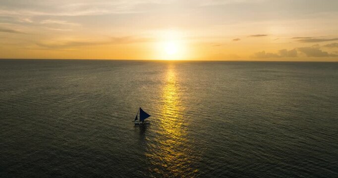 Boat over the sea with sunset reflection. Colorful cloudy sunset in Boracay, Philippines.