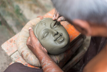 A artist making a idol face of a Hindu goddess