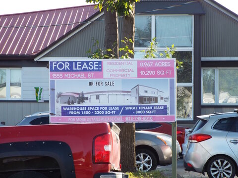 Ottawa, ON, Canada-July 8,2025: A "large pink and purple sign" at 1555 Michael St. advertises residential and commercial property for lease or for sale.