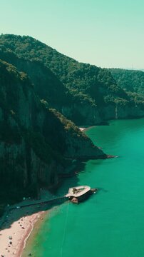 Aerial drone view of ancient basalt lava columns and wooden walkway at Guzelcehisar beach, unique volcanic rock formation on Black Sea coast, Turkey, 4K.