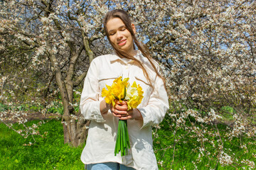 Young woman holding a bouquet of daffodils in her hands