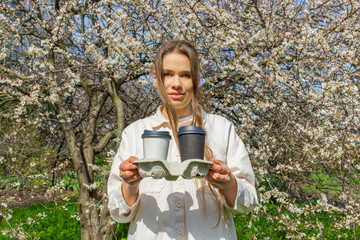 Young woman holding a takeaway coffee cups