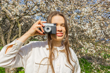 Young woman stands on the street, taking photos