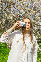 Young woman stands on the street, taking photos