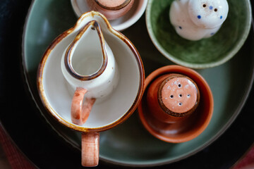 handmade ceramic tableware collection featuring rustic terracotta bowls, salt and pepper  shakers...