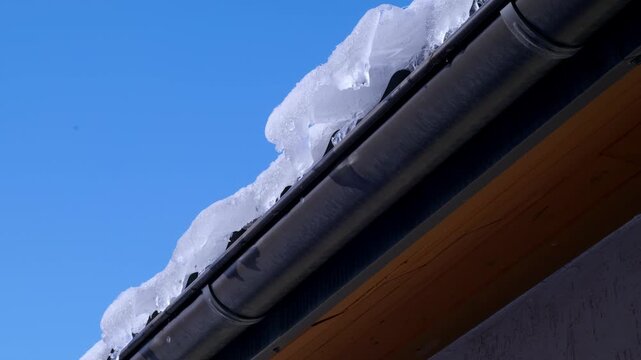 icicles melt in spring on the roof of the house