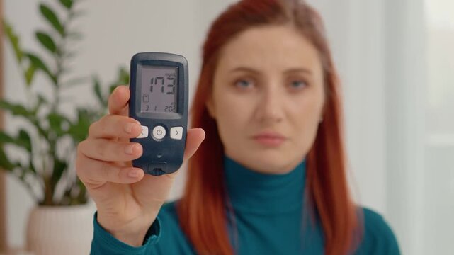 A woman holds a glucometer displaying a blood sugar reading of 173 mg dL. This level indicates high glucose, important for diabetes management.
