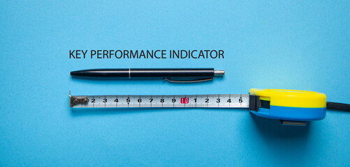 Tape measure with a text Key Performance Indicator on the blue background.