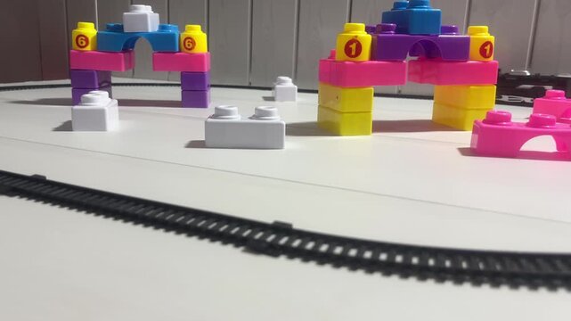 Toy Train Moving Through Colorful Track with Blocks and Play Structures