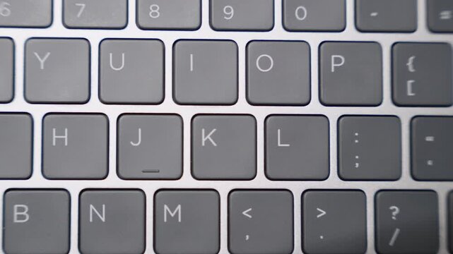Sideways camera movement across laptop keyboard showing keys in close-up detail.