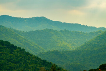 Naklejka premium Layers of Green Mountains in Soft Light Symbolizing Calm and Renewal