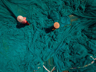 Obraz premium Aerial view of woman vietnamese fishermen with green fishing nets