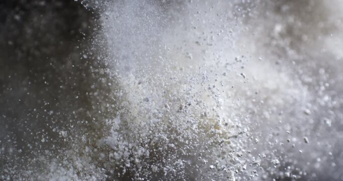Slow Motion Flour Powder Explosion On Black Background With Flying White Particles. Baking Ingredient Cloud, Abstract Food Texture, Dramatic Cinematic Dust Burst