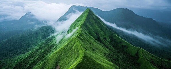 Aerial view of lush green mountains with mist covering the valleys