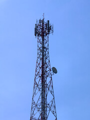 A tall communication tower against a clear blue sky, transmitting signals across a vast area. It represents connectivity and technological advancement