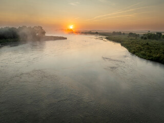 Obraz premium foggy sunrise over the Dismal River in Nebraska Sandhills at Nebraska National Forest, late summer morning scenery