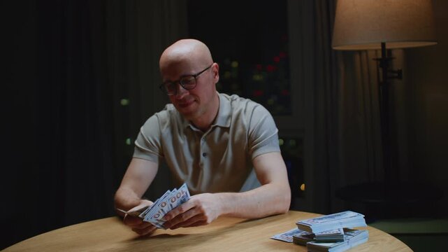 Close up: man trader or businessman counts salary usd banknotes at home with his hands. Male entrepreneur holds stack of dollar bills in palms, keeps money records for budget. Counting american paper