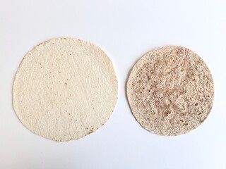 Comparison of fine white powder and coarse beige powder on white background, showing texture difference of natural granular materials in a simple minimal composition.