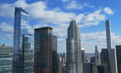 Fototapeta premium Glassy modern high rise buildings tower into the sky on a sunny autumn day.