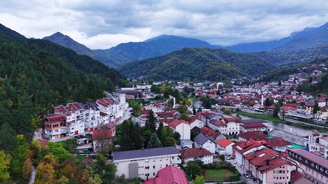 Aerial panorama of historic town with red roofs in gren mountain valley