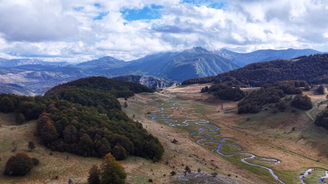 Aerial view of winding serpentine creek in high mountin valley
